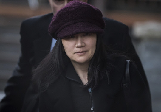 Huawei chief financial officer Meng Wanzhou, who is out on bail and remains under partial house arrest after she was detained Dec. 1 at the behest of American authorities, leaves her home to attend a court appearance regarding her bail conditions, in Vancouver, British Columbia, Tuesday Jan. 29, 2019. (Darryl Dyck/The Canadian Press via AP)